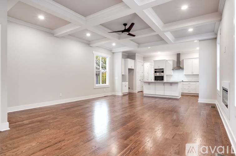 A spacious room with wooden floors and a ceiling fan.