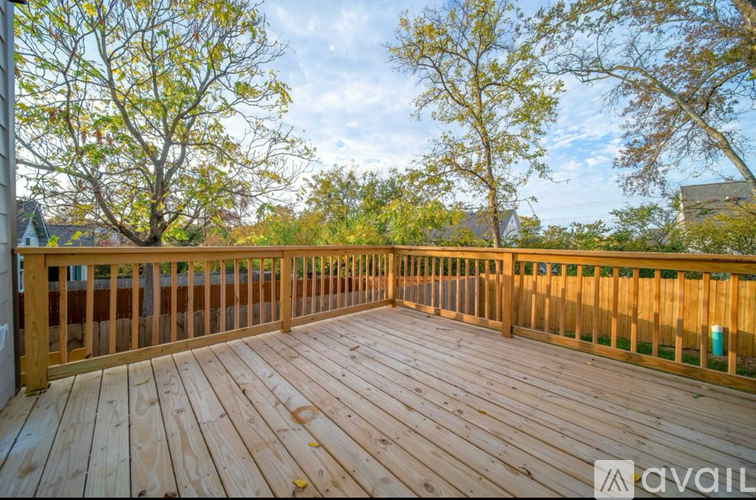 A wooden deck with a view of trees and houses.
