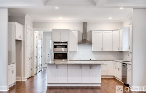 A modern kitchen with white cabinets and a central island.