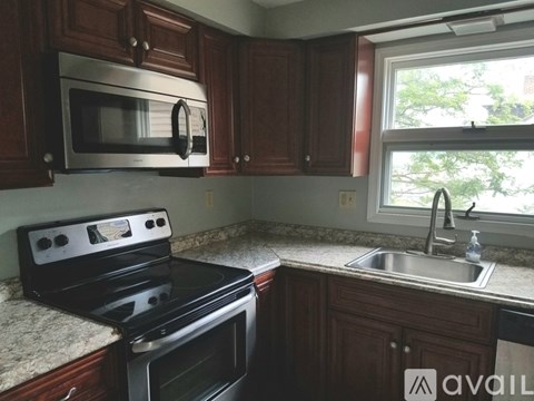 A kitchen with a stove, microwave, and sink.
