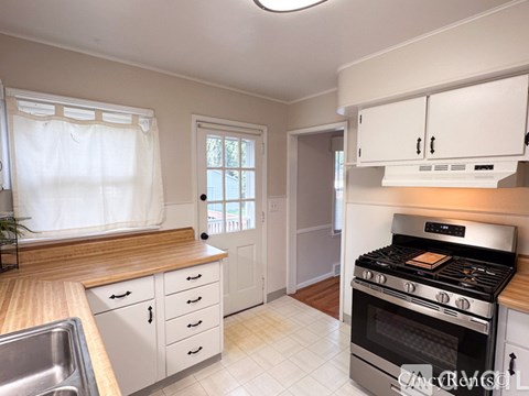 A kitchen with a stove top oven and a sink.