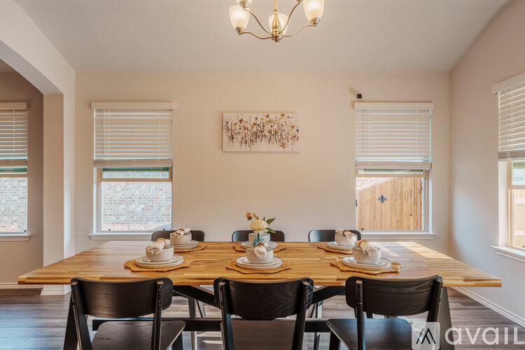 A dining room with a wooden table set for four.