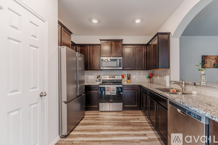 A kitchen with dark brown cabinets and stainless steel appliances.