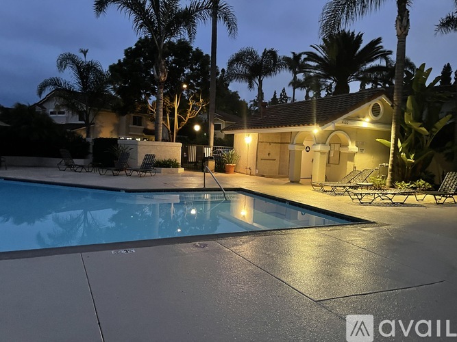 A pool surrounded by palm trees at night.