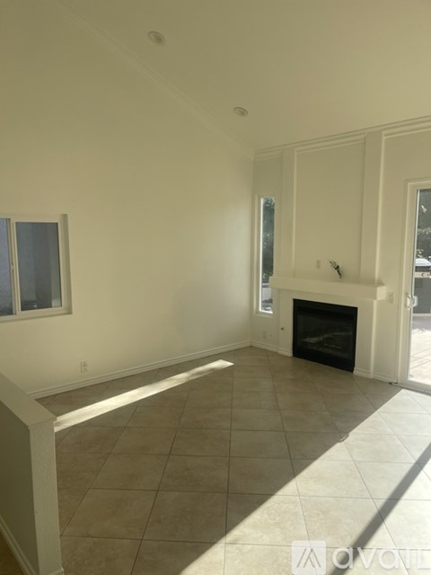 A spacious living room with a fireplace and sliding glass doors.