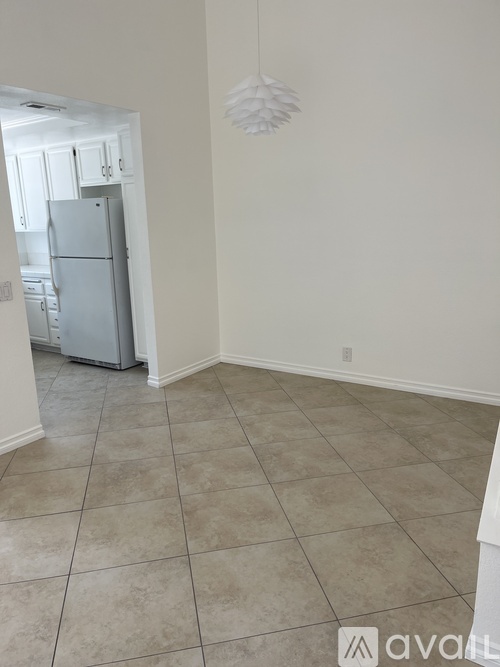 A kitchen with a refrigerator and a white ceiling light.