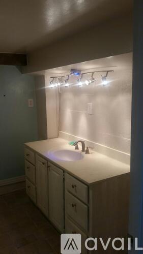 A bathroom with a sink and lights above it.