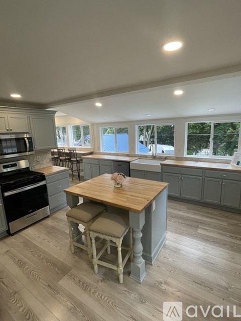 A kitchen with a wooden table and chairs in the middle of the room.