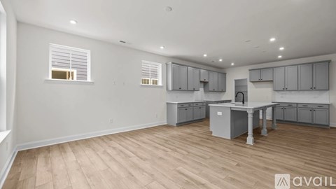 A spacious kitchen with grey cabinets and a central island.