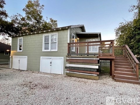 A two-story house with a deck and a garage.