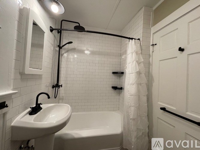 A white sink is on the left side of a white bathtub in a bathroom.