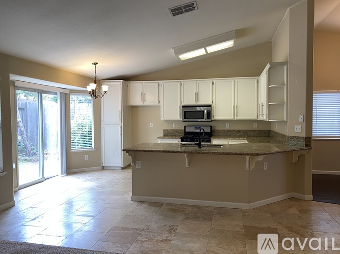 A kitchen with a microwave, oven, and sink.