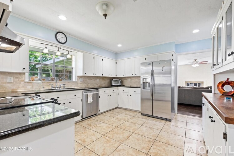 A kitchen with white cabinets and a tiled floor.