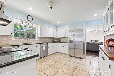 A kitchen with white cabinets and a tiled floor.