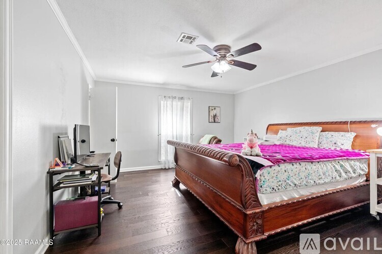 A bedroom with a bed, desk, and chair.