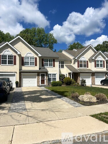 A two-story house with a driveway in front.