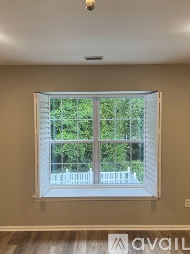 A bedroom with a large bed and a window with blinds.