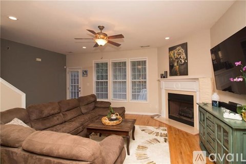 A living room with a brown couch and a fireplace.