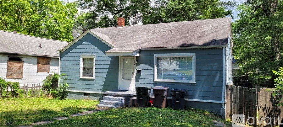 A blue house with a white window and a brown door.