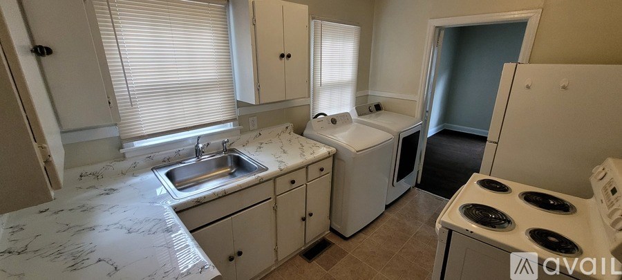 A kitchen with a white marble countertop and white cabinets.