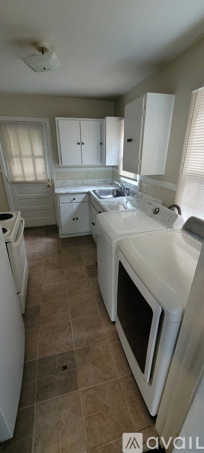 A kitchen with white appliances and cabinets.