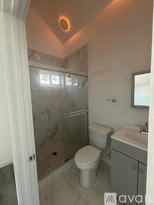 A bathroom with a toilet, sink, and shower.