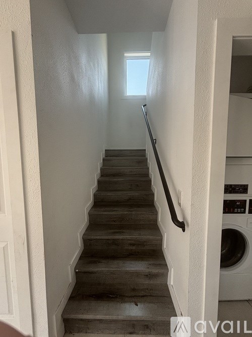 A staircase with wooden steps and a metal handrail.