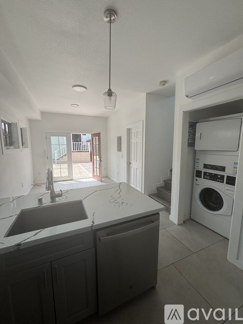 A kitchen with a washing machine in the corner.