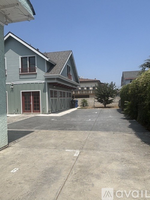 A blue house with a driveway in front.