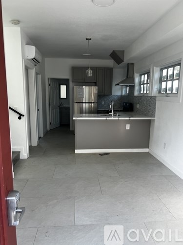 A kitchen with a refrigerator, sink, and stove top oven.