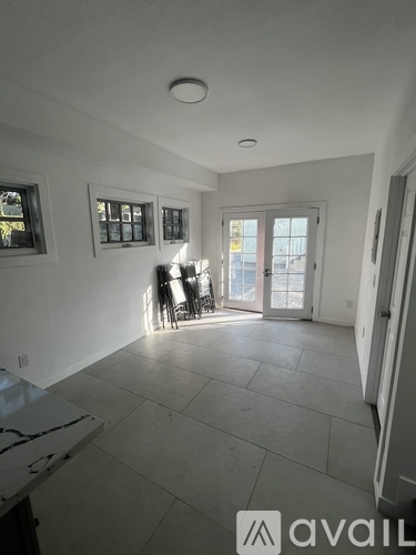 A spacious room with a marble countertop and a view of the backyard through the sliding glass door.