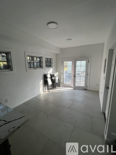 A spacious room with a marble countertop and a view of the backyard through the sliding glass door.