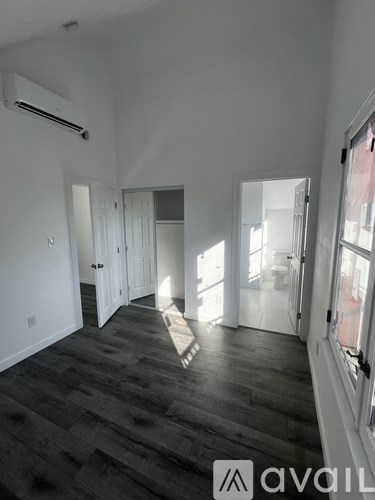 A room with wooden flooring and white walls.