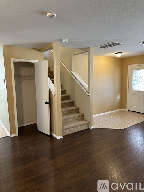 A spacious room with a staircase leading to the upper floor.