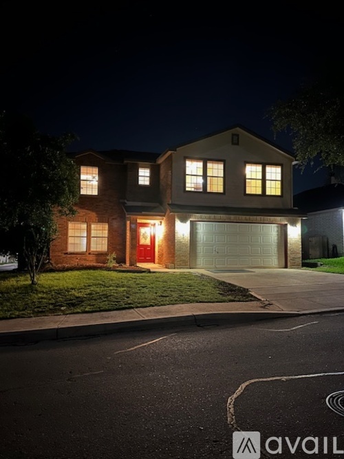 A house with a lit up garage door at night.