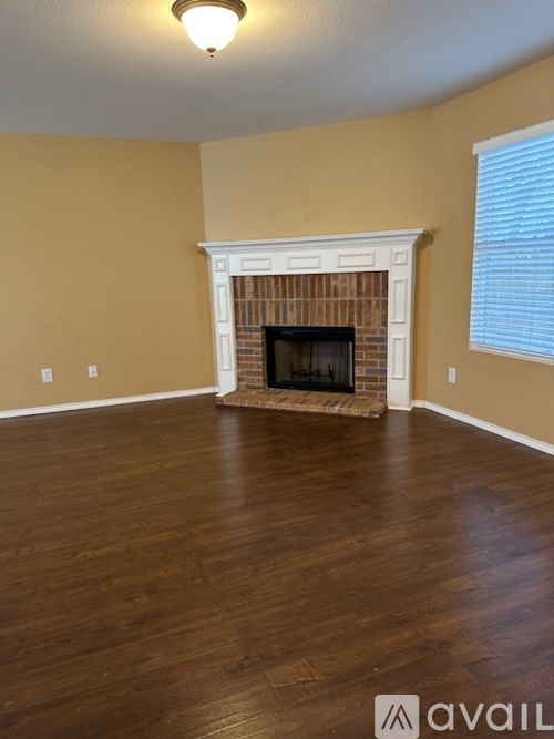 A living room with a fireplace and wood flooring.