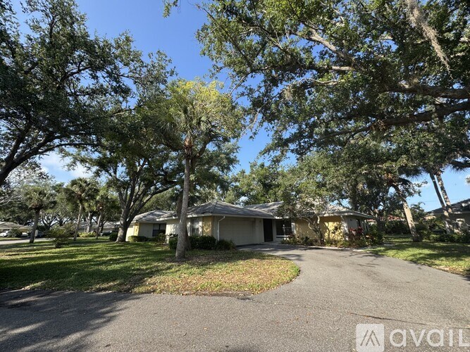 A house is for sale in a residential area with trees around.
