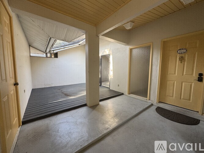 A room with a wooden door and a mat on the floor.