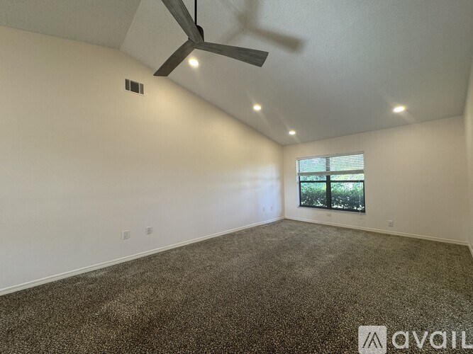A room with a ceiling fan and a window.