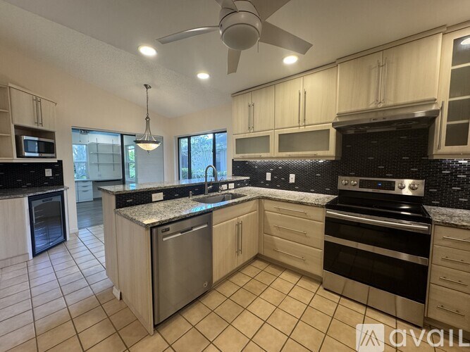 A kitchen with black countertops and stainless steel appliances.