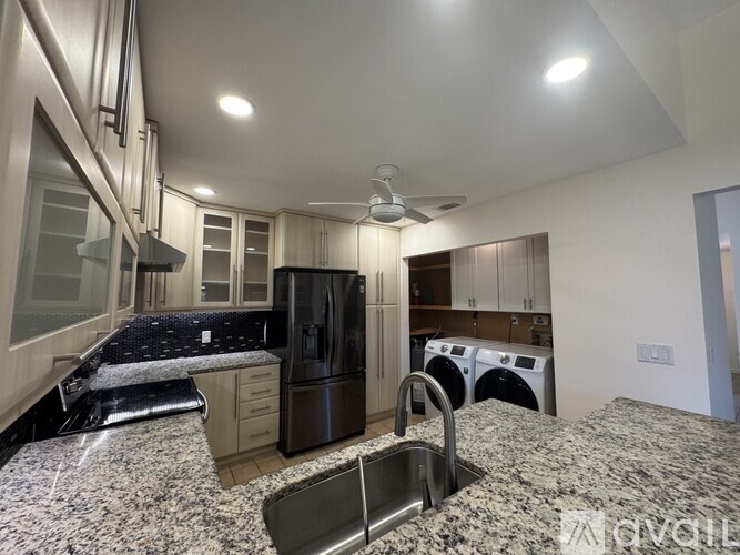 A modern kitchen with granite countertops and stainless steel appliances.