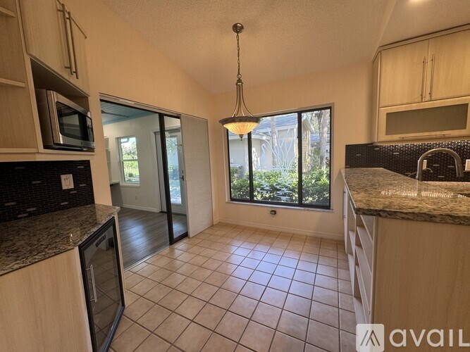 A kitchen with granite countertops and a microwave.