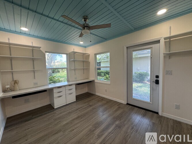 A room with a ceiling fan and a sliding glass door.