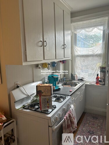 A kitchen with a white stove and cabinets.