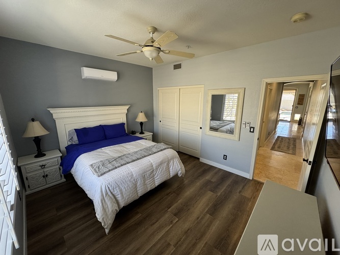 A bedroom with a large bed and a ceiling fan.