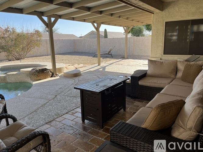 A patio with a table, chairs, and a hot tub.