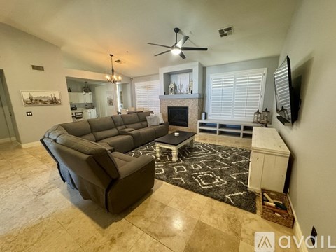 A living room with a large couch and a fireplace.