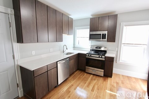 A kitchen with brown cabinets and a white countertop.