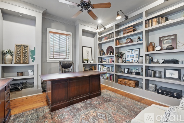 A room with a ceiling fan and shelves filled with various items.