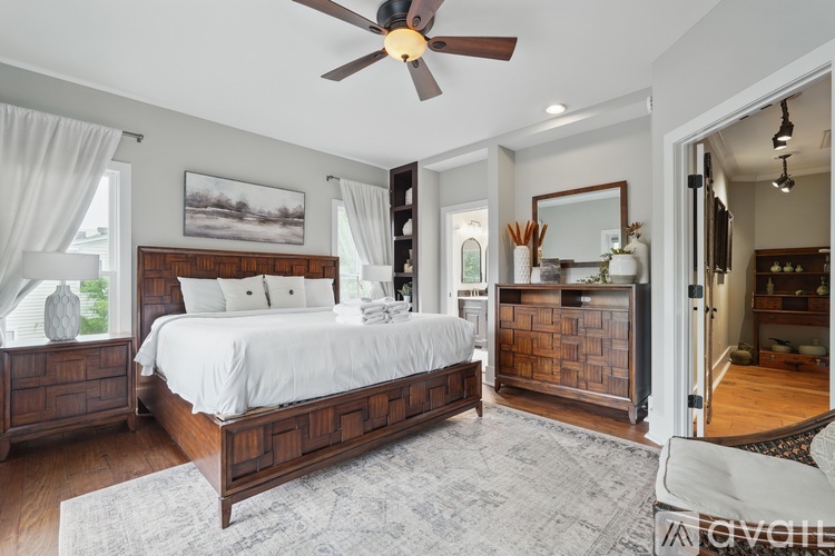 A bedroom with a large bed and a ceiling fan.